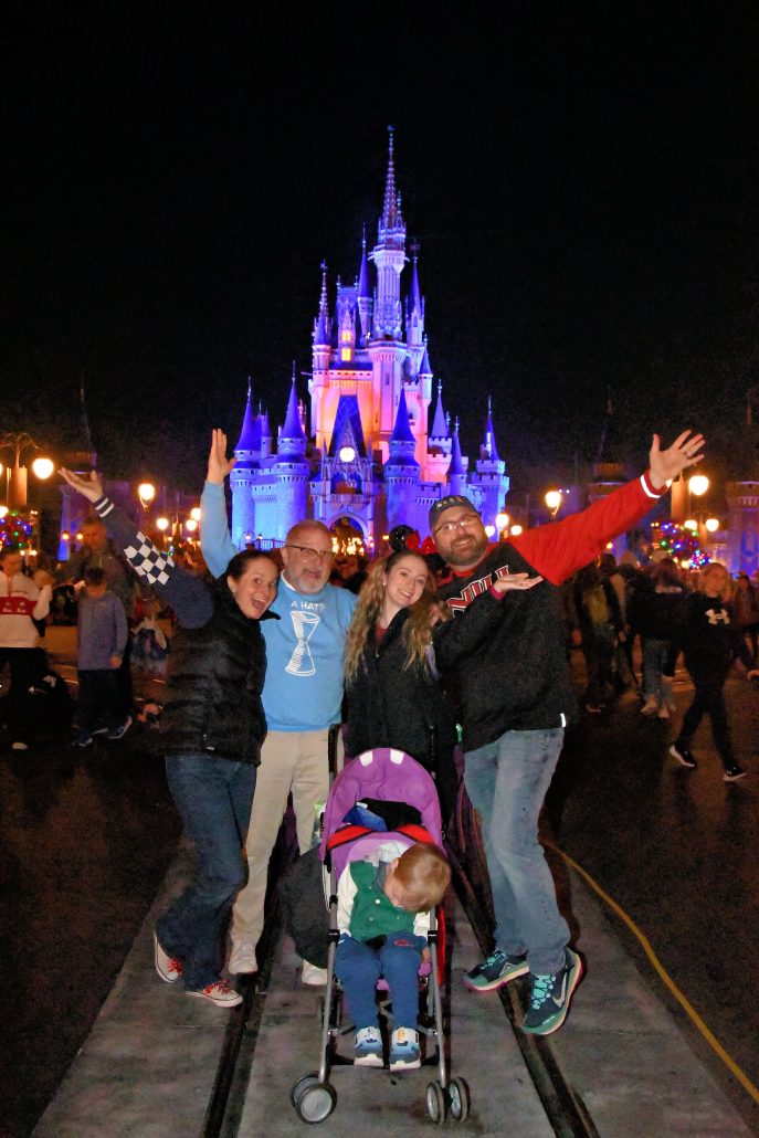 disney world with grandparents, family magic shot in front of cinderella castle at night