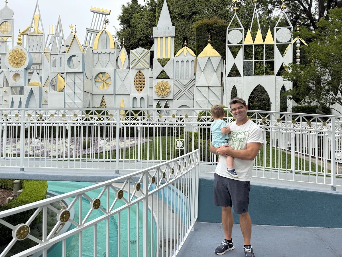 Toddler and dad in front of Disneyland's "it's a small world"